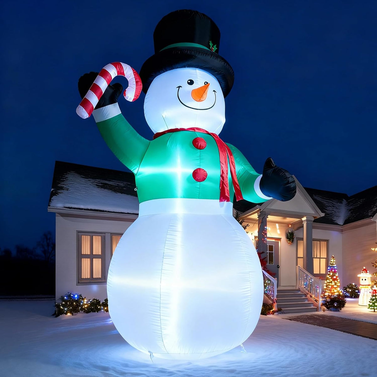 Giant glowing snowman inflatable in a top hat holding a candy cane at night