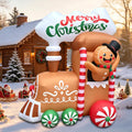 Gingerbread train inflatable with peppermint wheels and a waving gingerbread man under a Merry Christmas sign