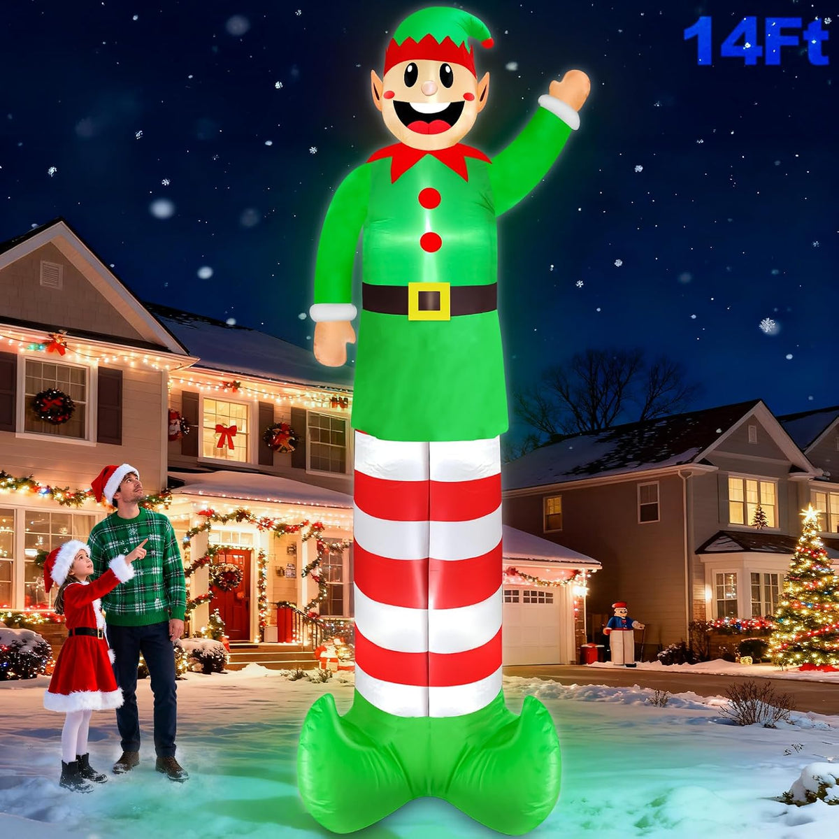 Giant elf inflatable in a green suit with striped legs waving beside a family in front of a house at night