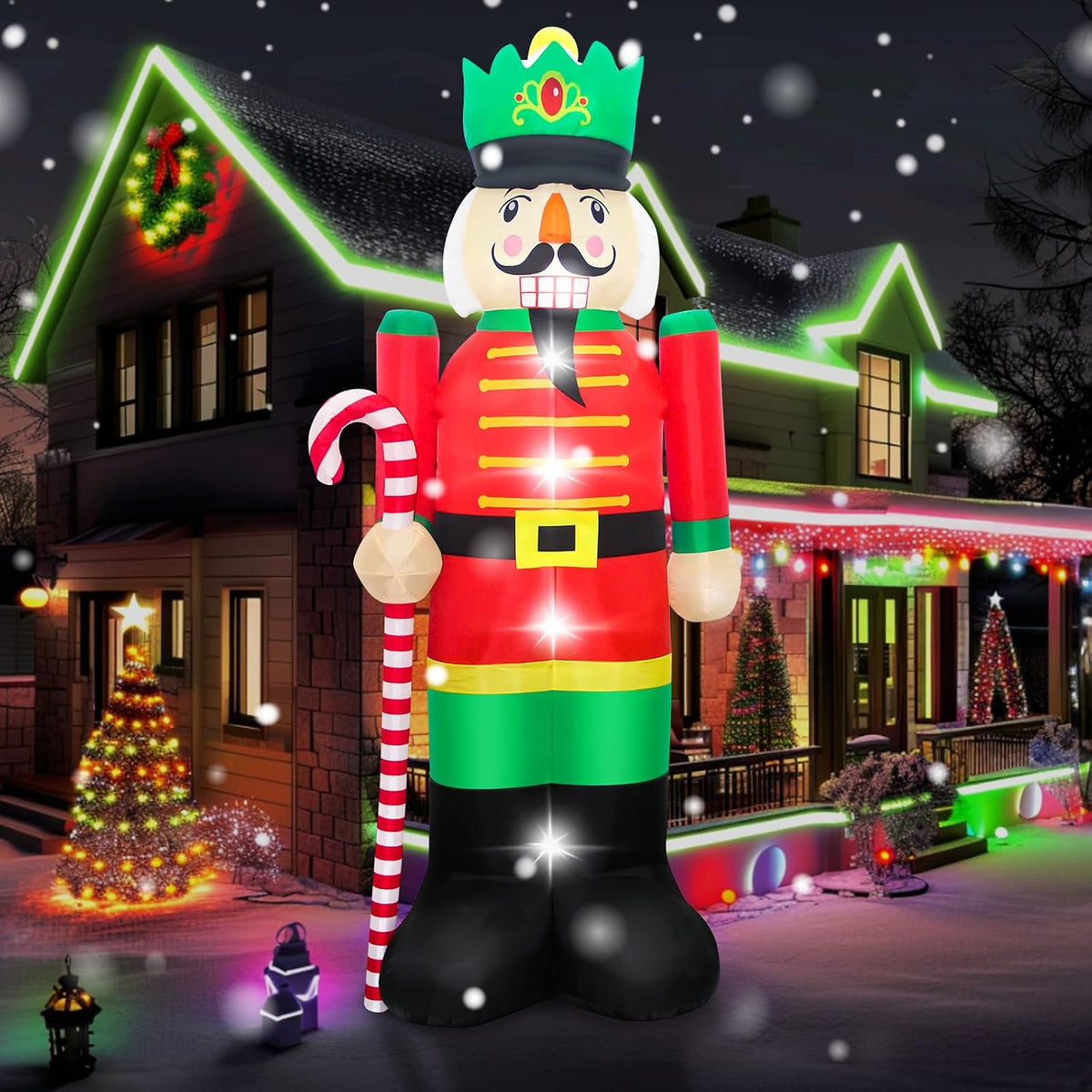 Giant nutcracker inflatable in a red coat and green crown holding a candy cane at night