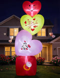 Tall stack of three heart inflatables on a red ring box glowing in front of a house at dusk