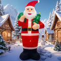 Giant Santa inflatable carrying a green gift sack and a small tree in a snowy village