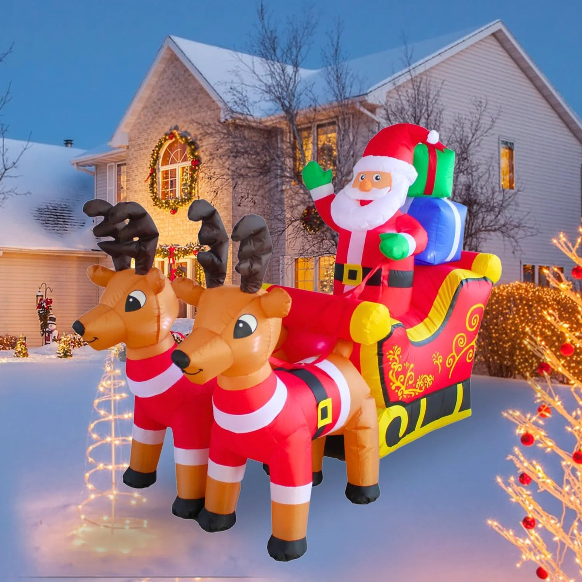 Santa in a red sleigh with gifts pulled by two reindeer inflatable in a snowy yard