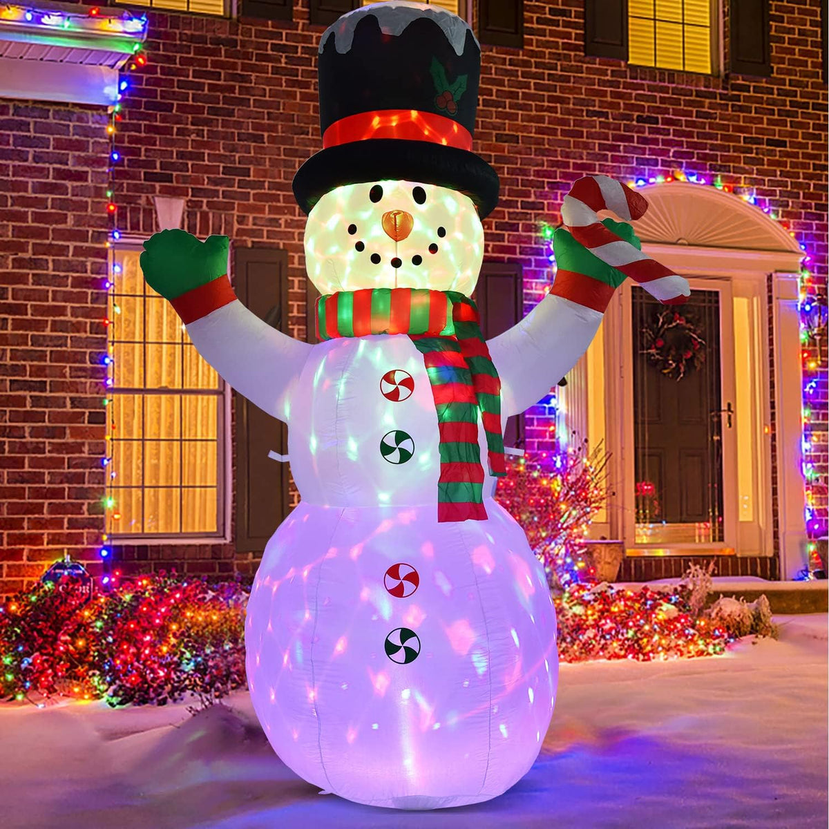 Snowman inflatable in a top hat with a glowing multicolor base in front of a brick house