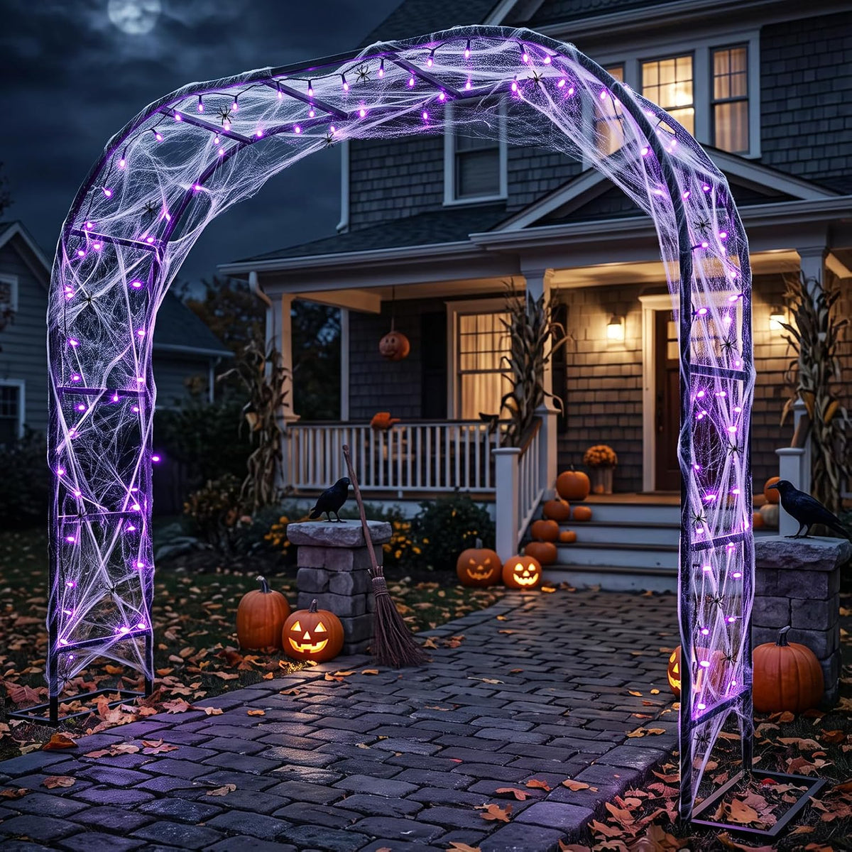 Black metal archway wrapped in purple lights and spider web over a front walk at night