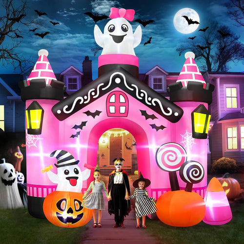 Pink castle Halloween arch inflatable with a ghost on top and candy decorations, kids in costume walking through