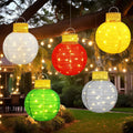 Five lighted pop-up Christmas ornament balls in white, red, yellow, green and silver hanging from a tree