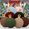 Eight velvet-finish inflatable Christmas ornaments in muted colors stacked in front of a wreath
