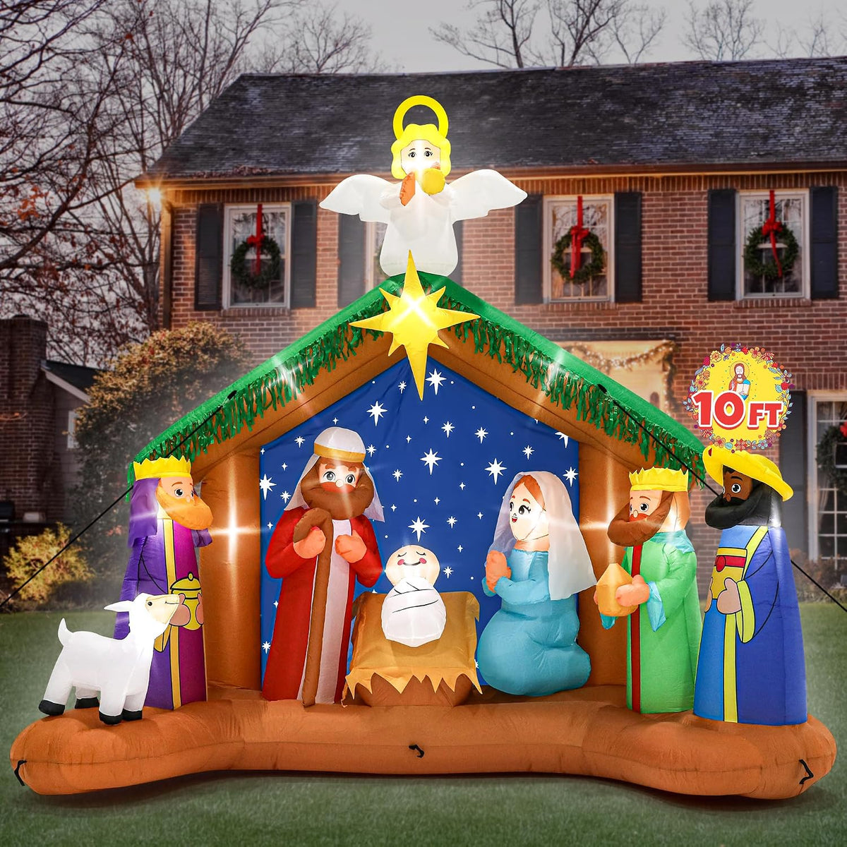 Wide nativity inflatable with the Holy Family, three kings, a lamb and an angel on the stable roof