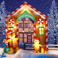 Gingerbread cookie house arch inflatable with a Happy Holiday sign and gingerbread figures in the snow