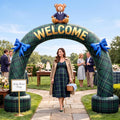 Green plaid WELCOME arch inflatable with a teddy bear on top at a baby shower in a garden