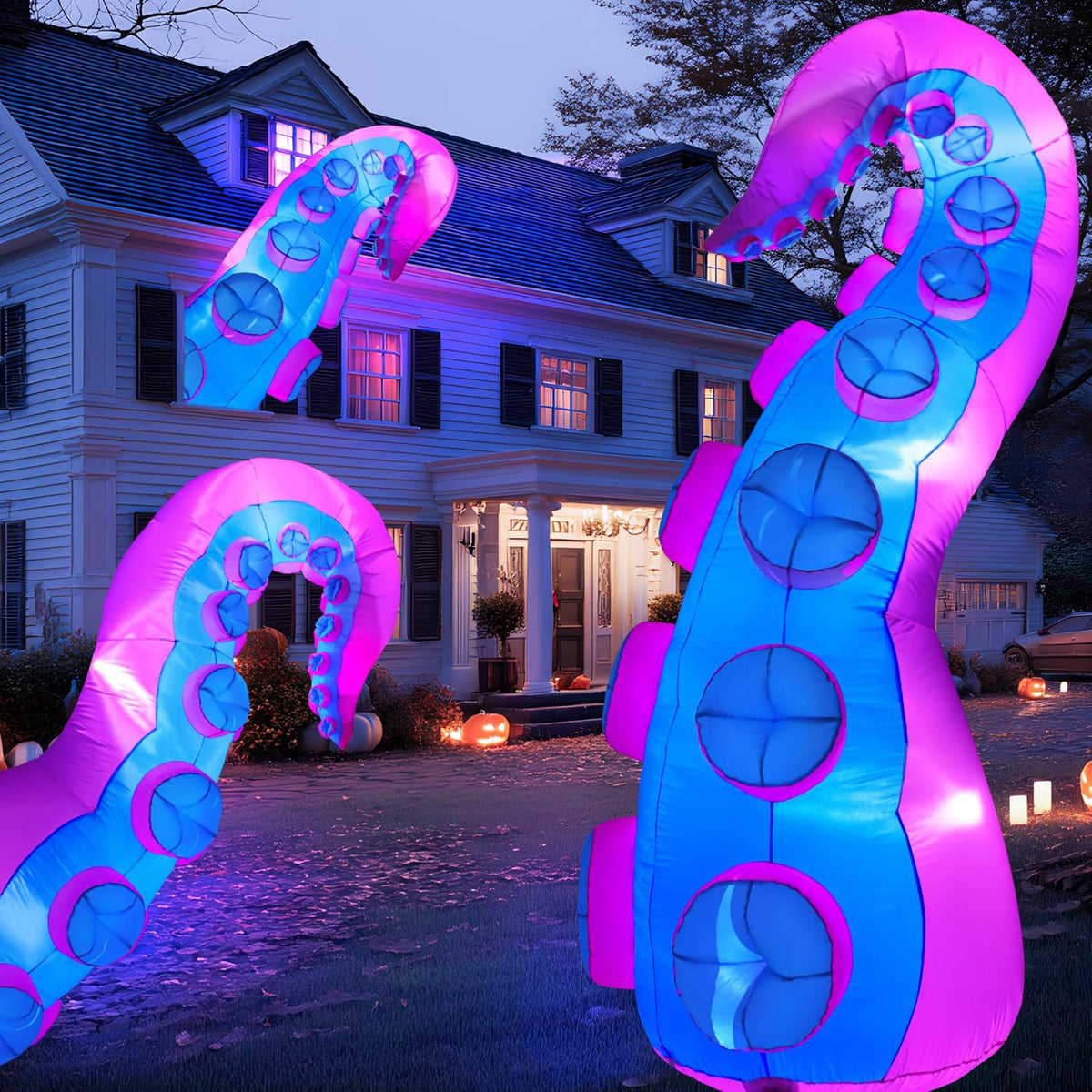 Pink and blue octopus tentacle inflatables rising from a front lawn at dusk